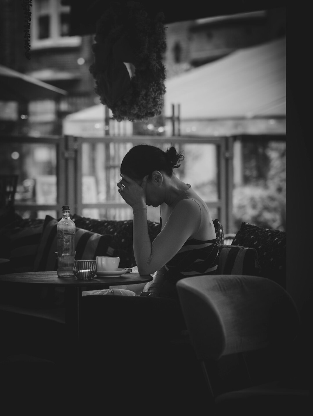 Young woman reading news on a laptop at a cafe table
