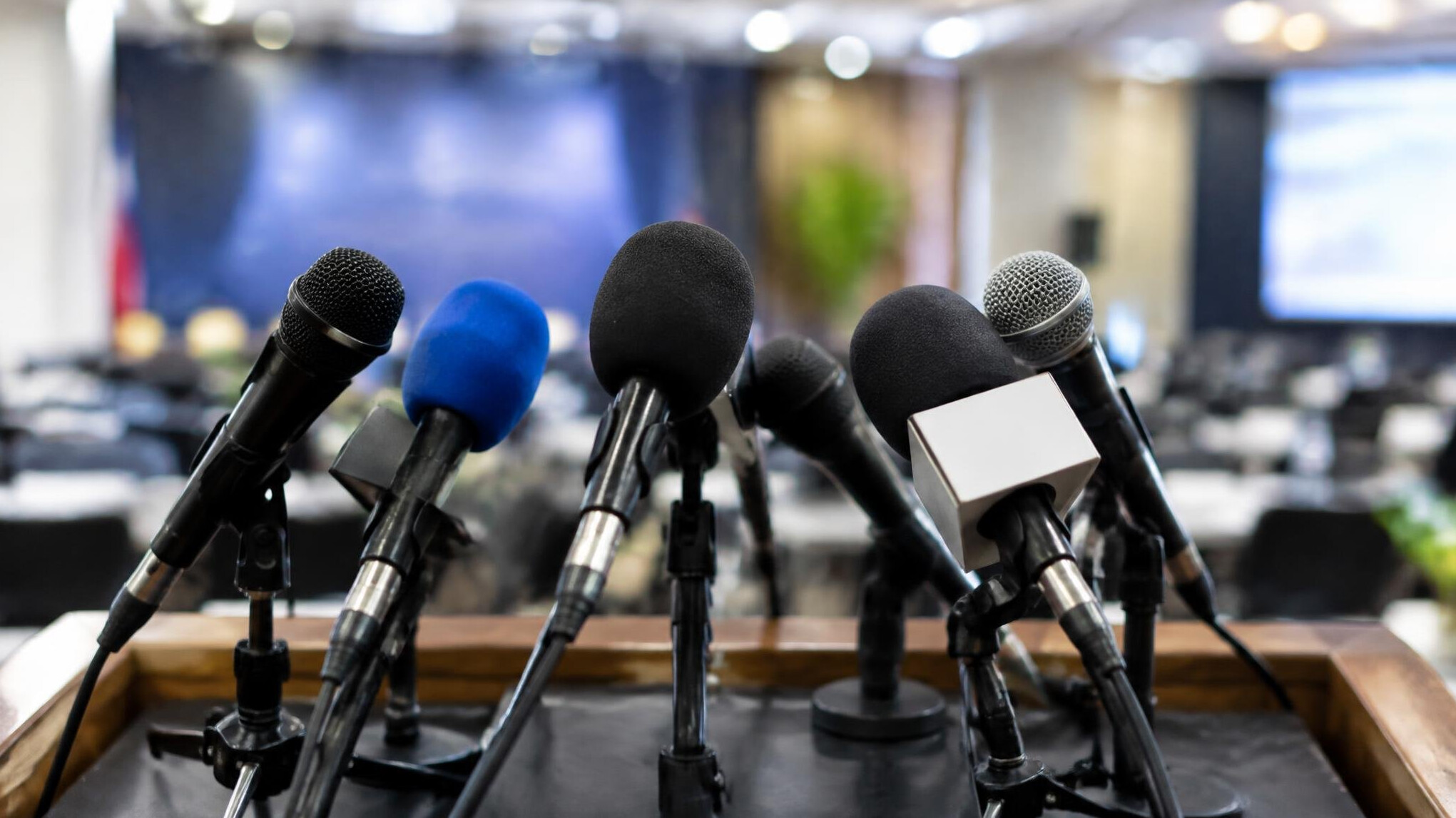 Row of microphones at a press conference podium