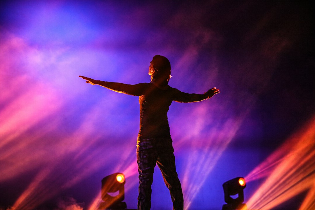 Concert stage with colorful lights and performer silhouette