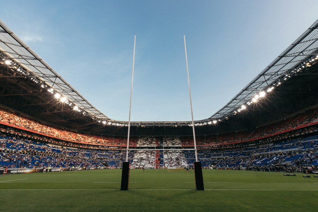 Large sports stadium filled with spectators under floodlights